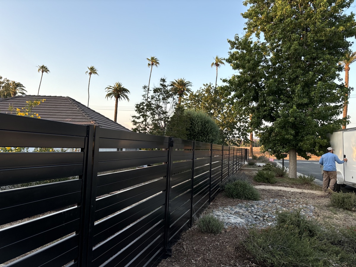 Aluminum horizontal slat fence with palm trees
